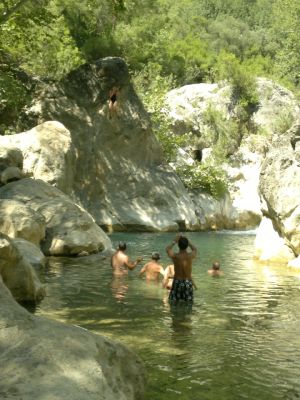 Girl jumping to the natural pool